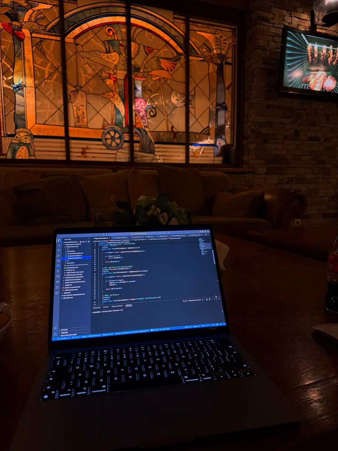 Code on a laptop in a dim café with stained-glass windows